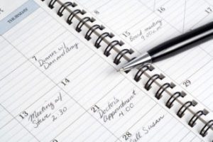 An open schedule planner book and pen.